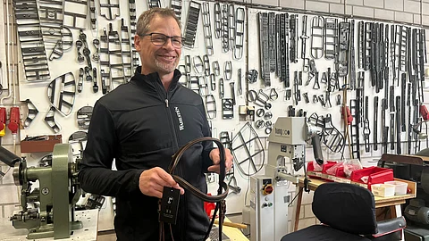 Toimitusjohtaja Tomi Himanka Velj. Wahlstenin tiloissa. Seinällä roikkuu nahan leikkuuseen ja muotoiluun käytettäviä meistirautoja ja pöydällä näkyy nahanompelukoneita.