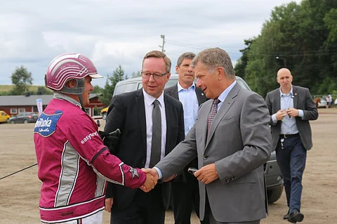 Suomen Hippoksen hallituksen puheenjohtaja Mika Lintilä isännöimässä tasavallan presidentti Sauli Niinistön ja ohjastaja Antti Teivaisen kohtaamista Turun kuninkuusraveissa 2016.
