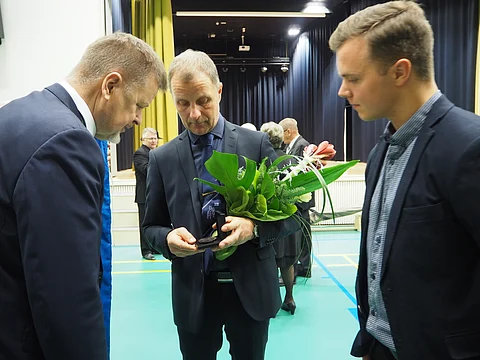 Esa Holopaisen saaman mitalin ulkoasu kiinnosti Keijo Rinnettä ja Ville Holopaista. Kuva: Stiina Ikonen