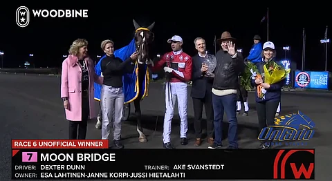 Iloisia ilmeitä Moon Bridgen kanssa voittoseremoniassa, oikealla vilkuttaa Esa Lahtinen. (Kuva: Woodbine Replays)
